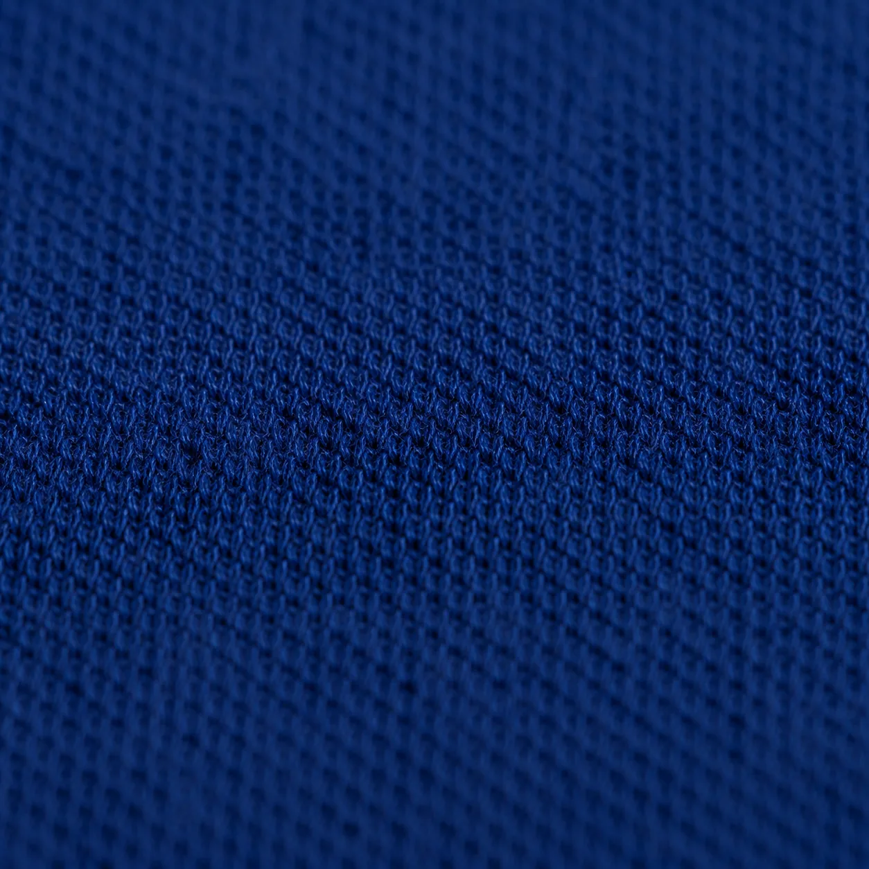 Close-up of the organic cotton piqué knit, the grain of the weave clearly visible.