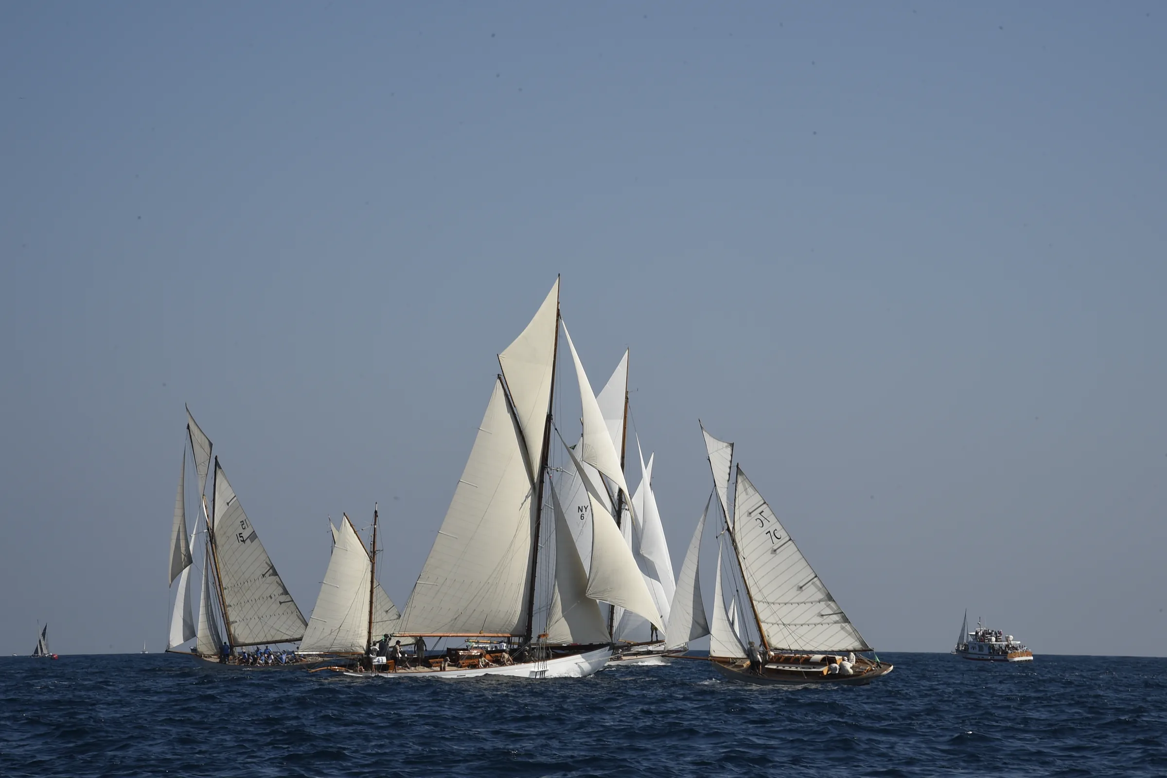 The fleet of classic yachts under sail in the gulf of Saint-Tropez, wooden rigs and off-white canvas.