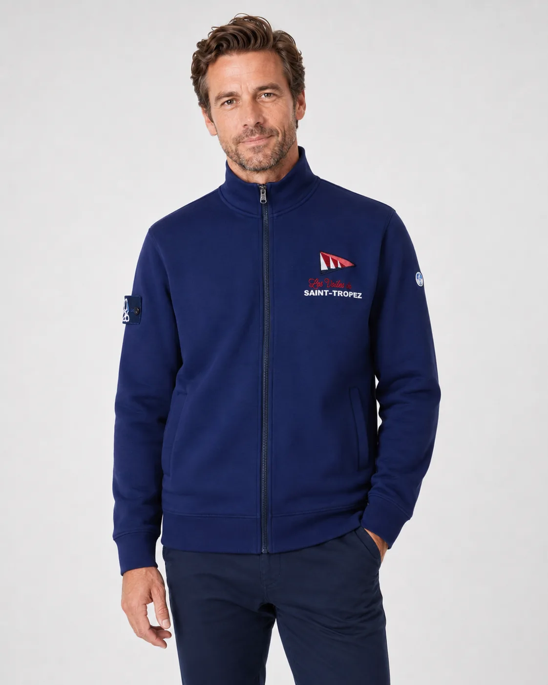 Full Zip 26 in navy worn from the front: stand collar, full-length zip, side pockets and the Les Voiles de Saint-Tropez pennant embroidered on the chest.