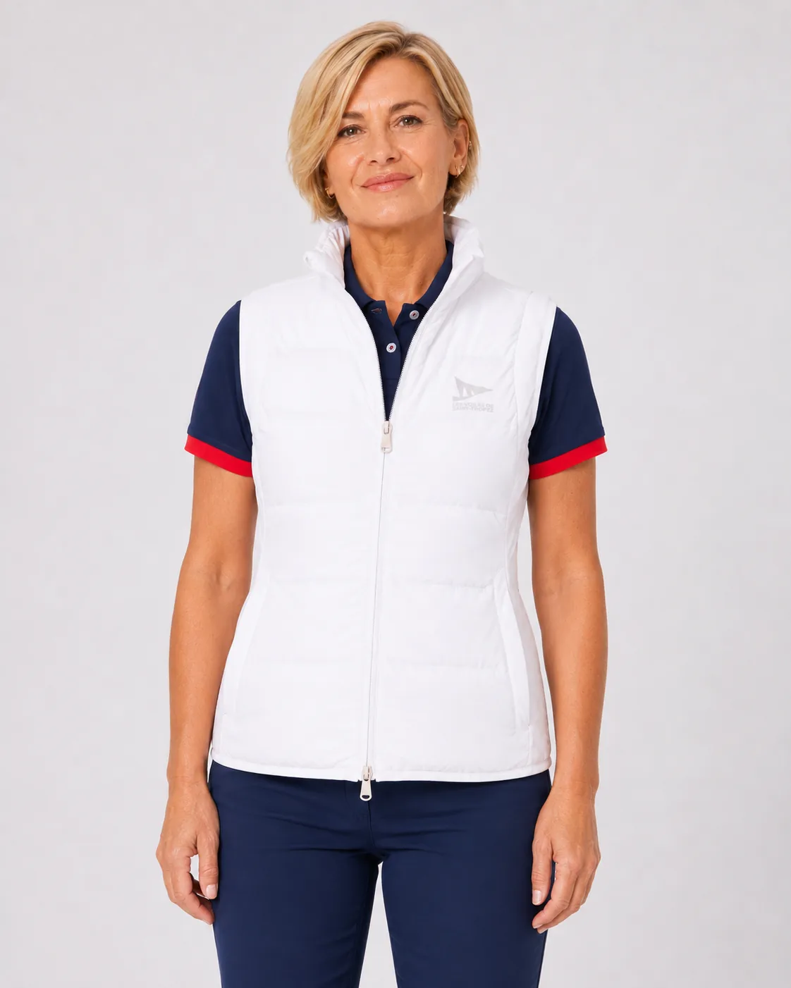 Gilet Sans Manches 26 in off-white worn over a navy polo: laser-welded quilting, stand collar, full-length zip and a tonal logo on the chest.