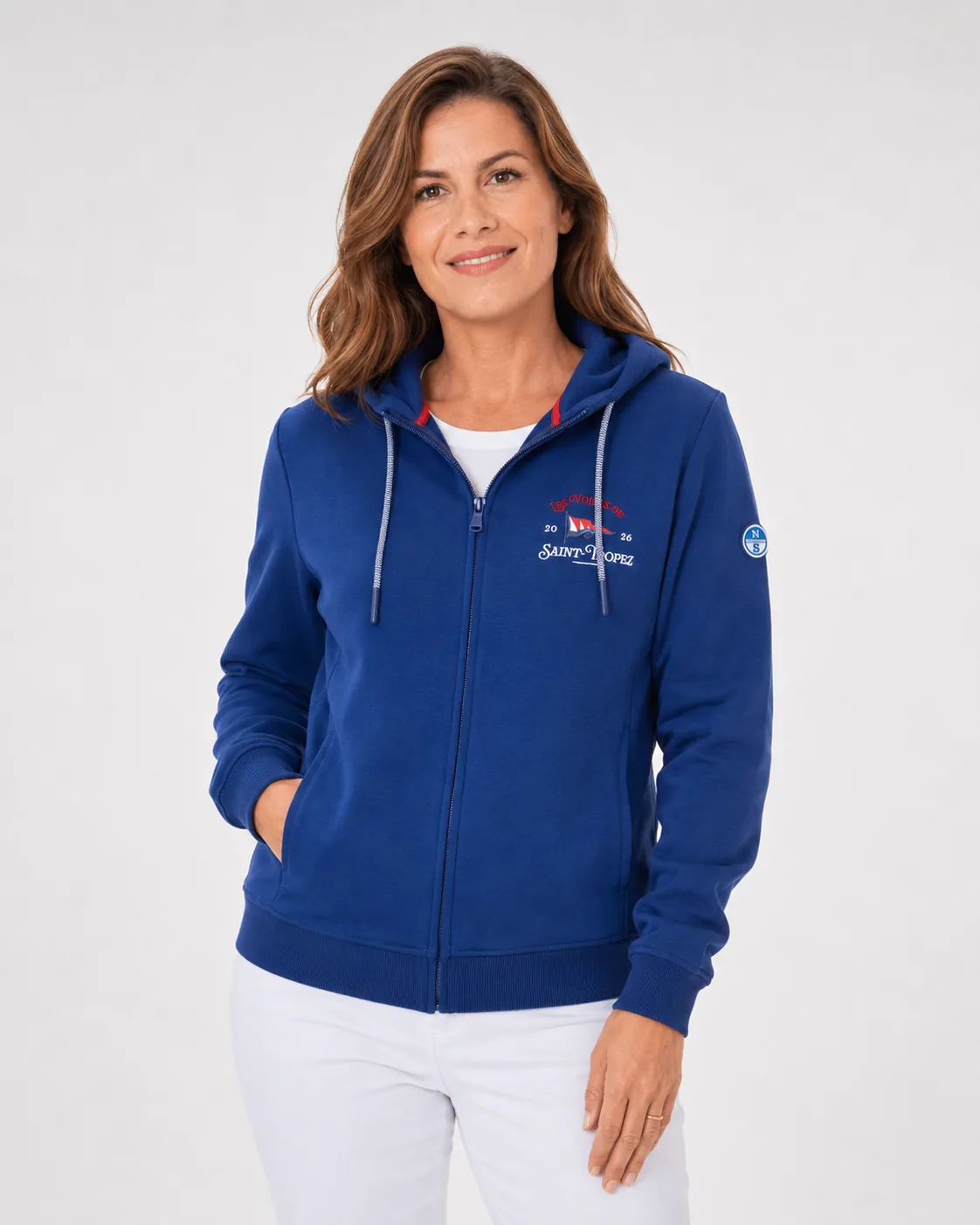 Veste Zippée Capuche 26 in midnight blue worn from the front: red-lined hood and Les Voiles de Saint-Tropez embroidery on the chest.
